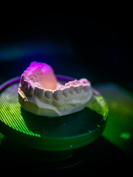 Closeup shot of a dental plaster model inside a scanner being scanned